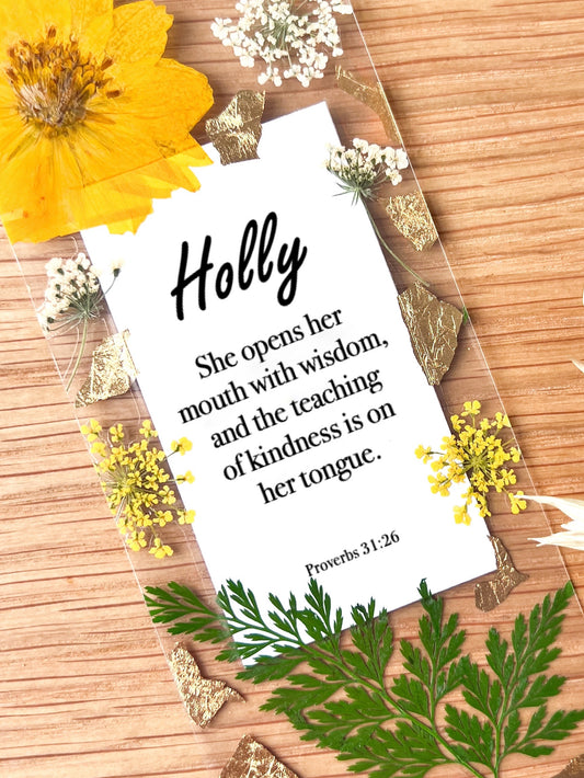 Pressed flower bookmark with bible passage "She opens her  mouth with wisdom, and the teaching  of kindness is on  her tongue.   Proverbs 31:26"