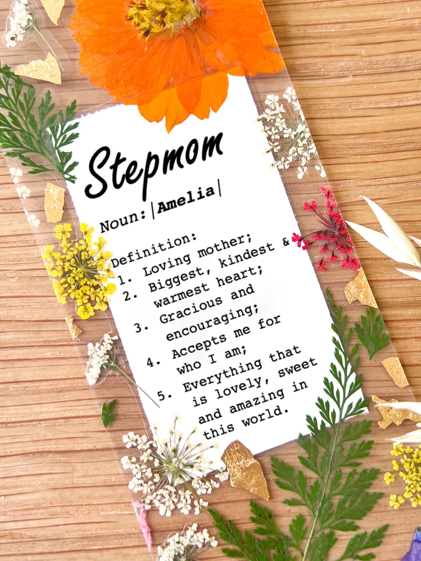 Pressed flower bookmark with the following quote "Stepmom  Noun:|Name|  Definition: 1.	Loving mother; 2.	Biggest, kindest  & warmest heart; 3.	Gracious and encouraging; 4.	Accepts me for  who I am; 5.	Everything that  is lovely, sweet and amazing in this world."