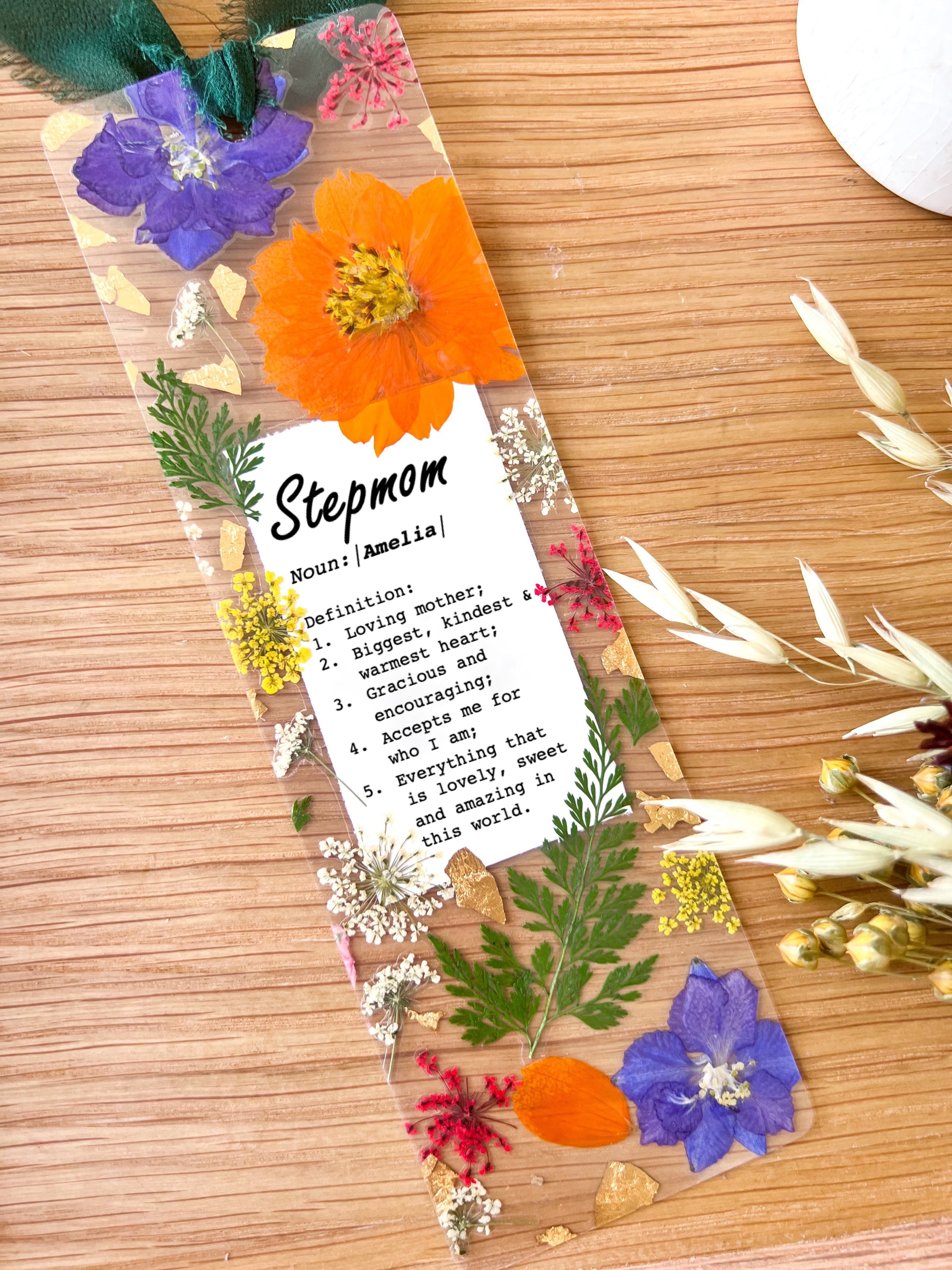 Pressed flower bookmark with the following quote "Stepmom  Noun:|Name|  Definition: 1.	Loving mother; 2.	Biggest, kindest  & warmest heart; 3.	Gracious and encouraging; 4.	Accepts me for  who I am; 5.	Everything that  is lovely, sweet and amazing in this world."