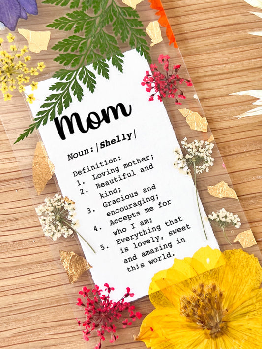 Bookmark includes the following message: Mom Noun:[custom name] Definition: 1. Loving mother; 2. Beautiful and kind; 3. Gracious and encouraging; 4. Accepts me for who I am; 5. Everything that is lovely, sweet and amazing in this world.