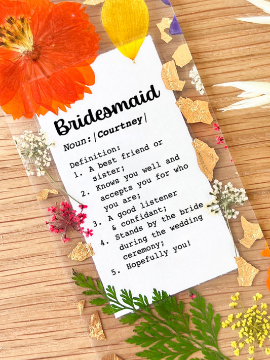 Bookmark includes the following quote : Bridesmaid [custom name] Definition: 1. A best friend or sister; 2. Knows me well and accepts me for who I am; 3. A good listener & confidant; 4. Stands by the bride during the wedding ceremony; 5. Hopefully you!